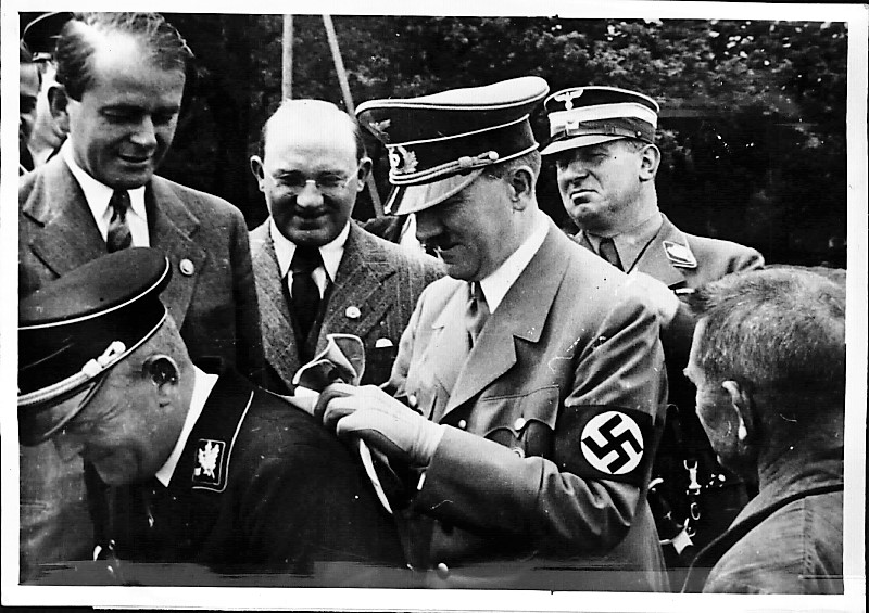 Adolf Hitler uses the back of SS-Obergruppenführer Schmauser to sign an autograph during a visit to the Reichs Congress Stadium in Nuremberg